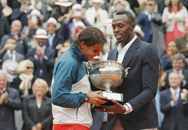 Dvě sportovní legendy - španělský tenista Rafael Nadal dostává trofej pro vítěze French Open od jamajského sprintera Usaina Bolta.