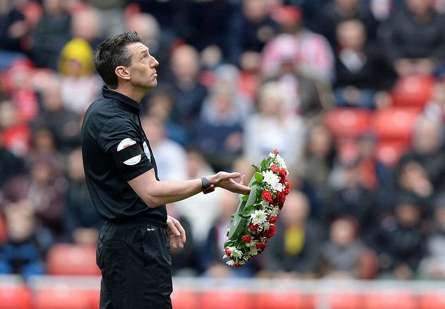 Rozhodčí Lee Probert drží věnec při minutě ticha za oběti tragédie v Hillsborough.