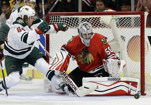 Gólman Chicaga Corey Crawford (50) vyráží střelecký pokus Mikaela Granlunda z Minnesoty.