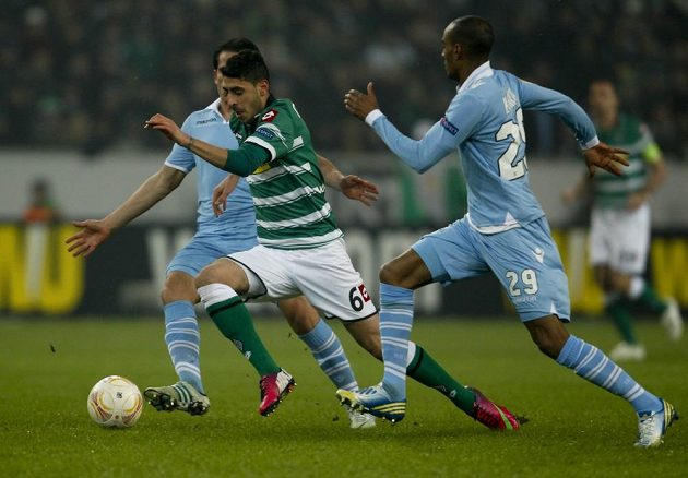 Cristian Ledesma (vlevo) a Abdoulay Konko (vpravo) z římského Lazia stíhají Tolgu Cigerciho z Borussie Mönchengladbach.