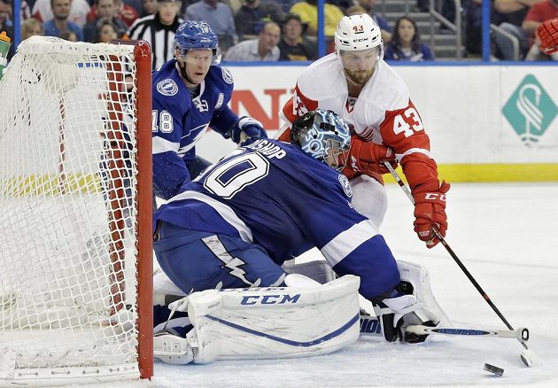 Gólman Tampy Ben Bishop (30) a Ondřej Palát (18) brání detroitskému Darrenu Helmovi (43).