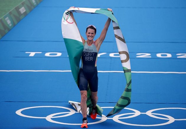 Triatlonistka Flora Duffyová z Bermud slaví vítězství v olympijském závodu a zároveň první zlato pro svou zemi v historii soutěží pod pěti kruhy.