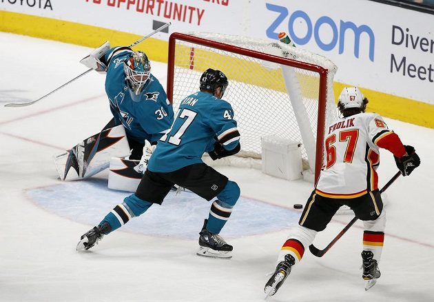 Útočník Michael Frolík (67) sleduje, jak puk končí v brance San Jose Sharks během utkání NHL. Český střelec se později sám také zapsal mezi střelce.