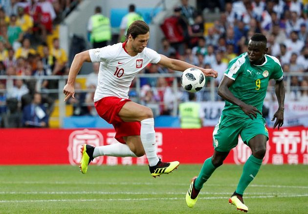 Polský fotbalista Grzegorz Krychowiak v akci, pokouší se v utkání MS obejít senegalského soupeře, kterým byl Mame Biram Diouf.