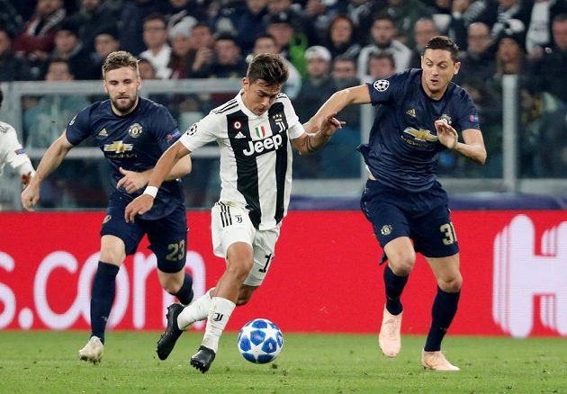 Fotbalista Juventusu Paulo Dybala se snaží prosadit přes duo z Manchesteru United ve složení Luke Shaw - Nemanja Matič.