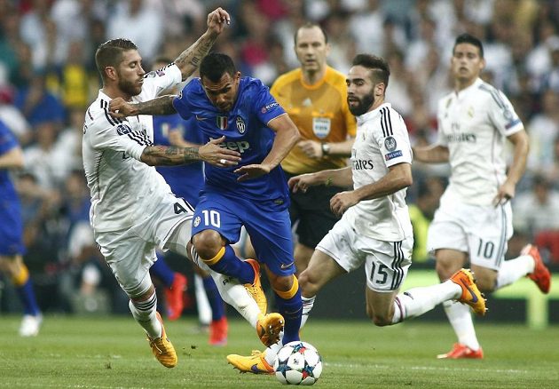 Útočník Juventusu Carlos Tévez (10) prochází přes obránce Realu Madrid Sergia Ramose a Daniho Carvajala (vpravo).