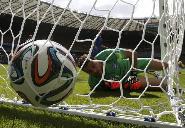 Řecký brankář Orestis Karnezis se smutně dívá za míčem, který mu do sítě šoupl Kolumbijec Pablo Armero.