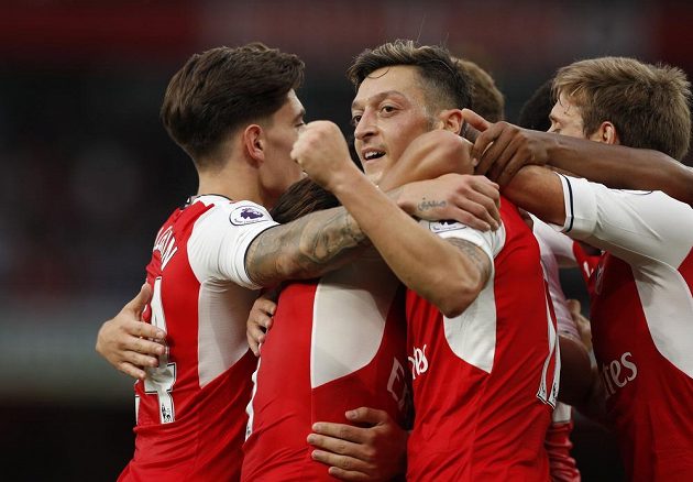 Záložník Arsenalu Mesut Özil (uprostřed) slaví se spoluhráči gól v síti Chelsea.