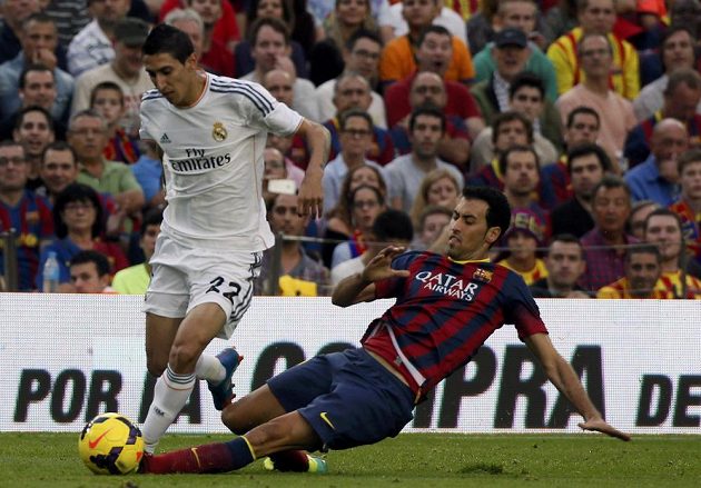 Sergio Busquets z Barcelony (vpravo) se snaží skluzem zastavit Ángela Di Mariu z Realu Madrid.