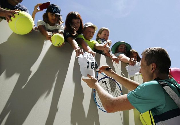 Tomáš Berdych rozdává autogramy fanouškům po vítězném vstupu do grandslamového šampionátu v Melbourne.