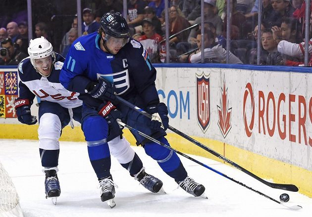 Anže Kopitar z Výběru Evropy (vpravo) a boj o puk s Johnem Carlsonem z USA během utkání Světového poháru.