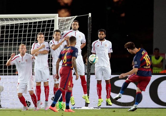 Lionel Messi z Barcelony (zcela vpravo) střílí z přímého volného kopu gól do sítě Sevilly.