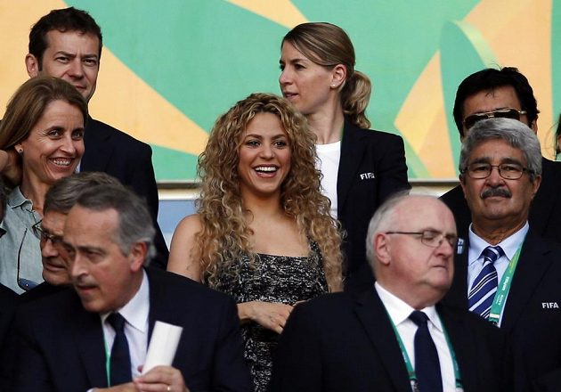 Kolumbijská zpěvačka Shakira (uprostřed), partnerka španělského obránce Gerarda Piquého, se usmívá v čestné lóži před zahájením semifinále Poháru FIFA proti Itálii.