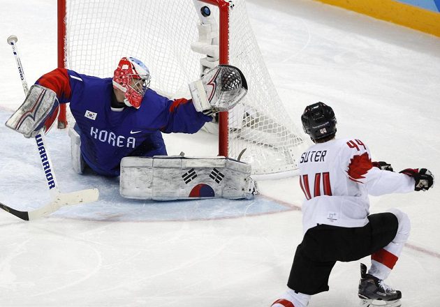Švýcarský hokejista Pius Suter překonává korejského gólmana Matta Daltona v utkání olympijského turnaje.