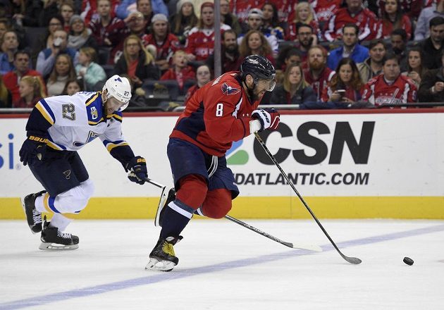 Ruský snajpr Washingtonu Alexandr Ovečkin prchá v utkání proti St. Louis Blues obránci soupeře Alexi Pietrangelovi.