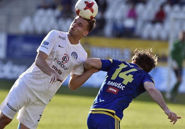 Vlastimil Daníček ze Slovácka odvrací míč před jihlavským útočníkem Michaelem Rabušicem.