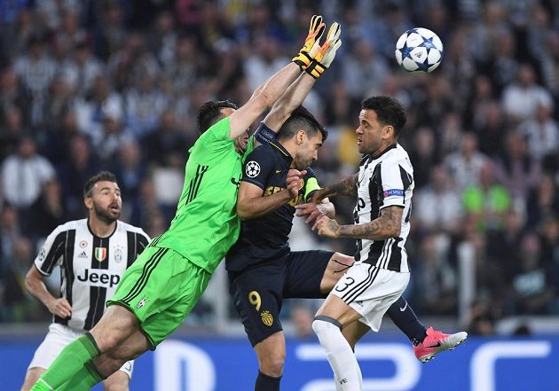 Brankář Juventusu Gianluigi Buffon vyráží míč před hlavičkujícím Radamelem Falcaem z Monaka.