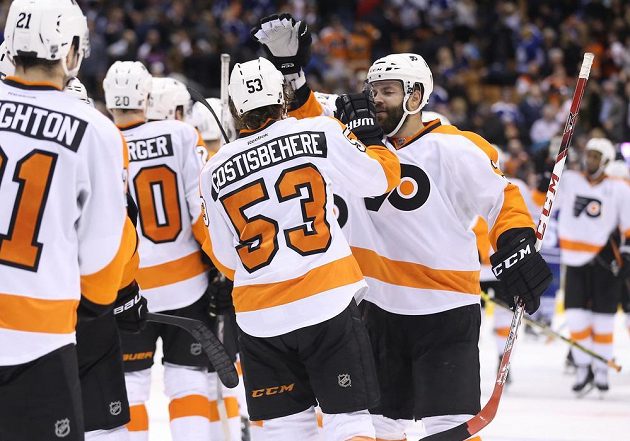 Obránce Philadelphie Radko Gudas (3) gratuluje Shaynehovi Gostisbeherehovi (53), který vstřelil vítězný gól do sítě Toronta v zápase NHL.