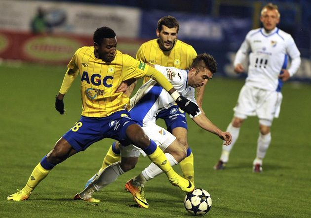 Teplický záložník Franci Litsingi (vlevo) se snaží zastavit Davora Kukece z Baníku Ostrava (v bílém dresu uprostřed). Vzadu ve žlutém dresu přihlíží teplický záložník Admir Ljevakovič.