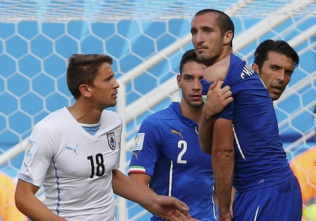 Giorgio Chiellini ukazuje rozhodčímu rameno, kam ho o chvíli dříve kousl uruguayský útočník Luis Suárez.