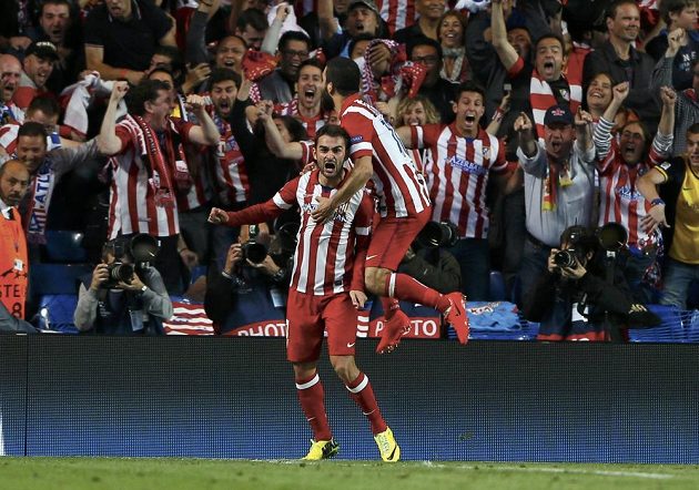 Fotbalisté Atlétika Madrid Adrián López (vlevo) a Arda Turna slaví s fanoušky gól proti Chelsea.