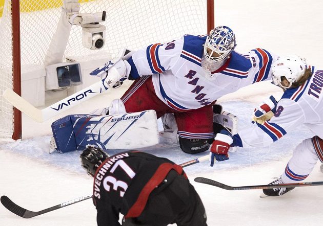Ruský křídelník Caroliny Andrej Svečnikov překonává gólmana New York Rangers Henrika Lundqvista a završuje hattrick, zákrok obránce Jacoba Trouby už přišel pozdě.