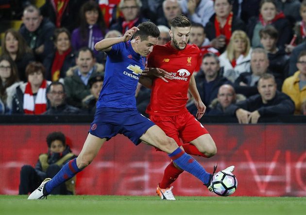 Záložník Manchesteru United Ander Herrera bere míč střídajícímu Adamu Lallanovi z Liverpoolu.