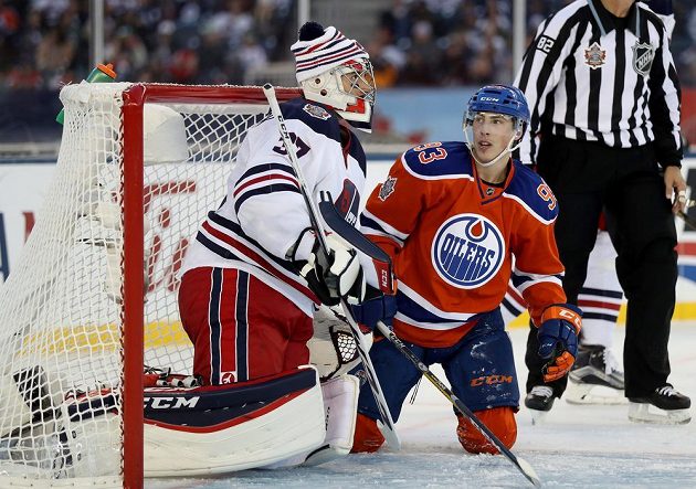 Útočník Edmontonu Ryan Nugent-Hopkins před brankářem Winnipegu Connorem Hellebuyckem.