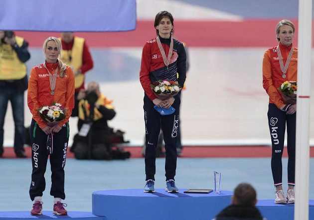 Martina Sáblíková na nejvyšším stupínku při medailovém ceremoniálu na MS po závodě na 5 km. Vlevo broznová Irene Schoutenenová, vpravo stříbrná Carien Kleibeukerová.