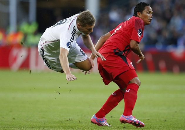 Posila Realu Madrid Toni Kroos padá po souboji s útočníkem Sevilly Carlosem Baccou.