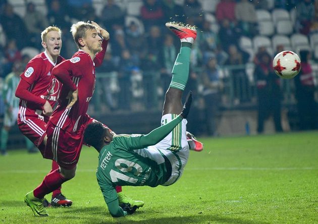 Zleva Václav Jemelka, David Houska ze Sigmy Olomouc sledují akrobatický počin Benjamina Tetteha z Bohemians v utkání 13. kola první fotbalové ligy.