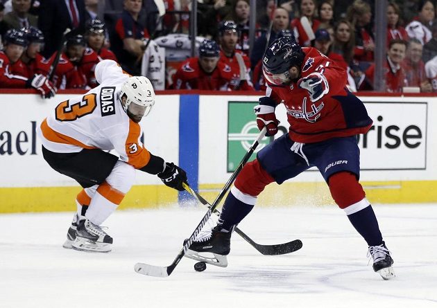 Český obránce Radko Gudas z Philadelphie bojuje o puk s Jevgenijem Kuzněcovem z Washingtonu.