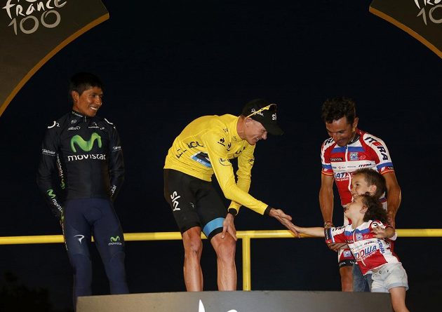 Britský cyklista Christopher Froome (uprostřed) přijímá od dětí gratulace k vítězství v Tour de France. Vlevo Kolumbijec Nairo Alexander Quintana, vpravo Španěl Joaquim Rodríguez.