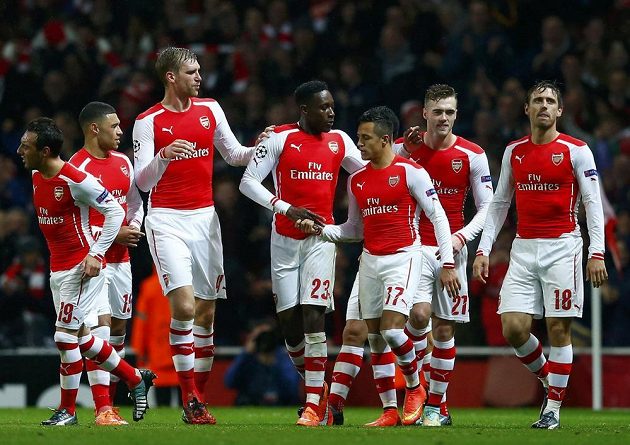 Alexis Sánchez (uprostřed) přijímá gratulace od spoluhráčů z Arsenalu ke gólu proti Anderlechtu ve 4. kole Ligy mistrů.