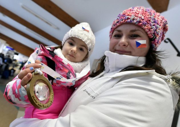Čtyřletá Kristínka Doležalová z Prahy (na snímku s maminkou) se zlatou medailí, kterou jí daroval vítěz závodu Martin Fourcade z Francie.