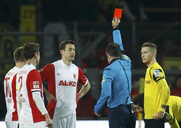 Rozhodčí Marco Fritz uděluje červenou kartu Christophu Jankerovi (třetí zleva) z Augsburgu v utkání 19. kola bundesligy.