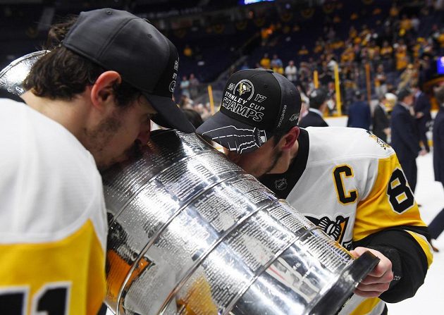 Hvězdy Pittsburghu Penguins Sidney Crosby (87) a Jevgenij Malkin (71) líbají Stanley Cup. Tučňákům se po výhře 2:0 na ledě Nashvillu povedlo trofej obhájit.
