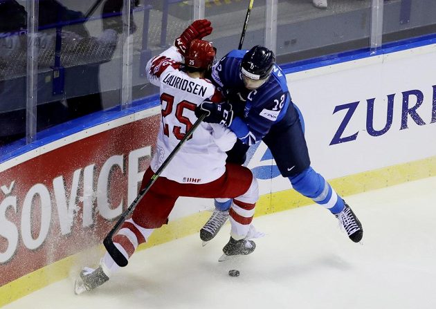 Dánský hokejista Oliver Lauridsen v akci během mistrovství světa v utkání s Finskem. do souboje s ním jde Fin Marko Anttila.
