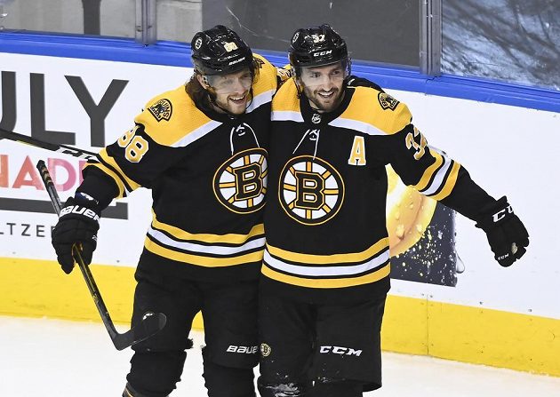 David Pastrňák (vlevo) slaví vítěznou trefu Bostonu s jejím autorem Patricem Bergeronem.