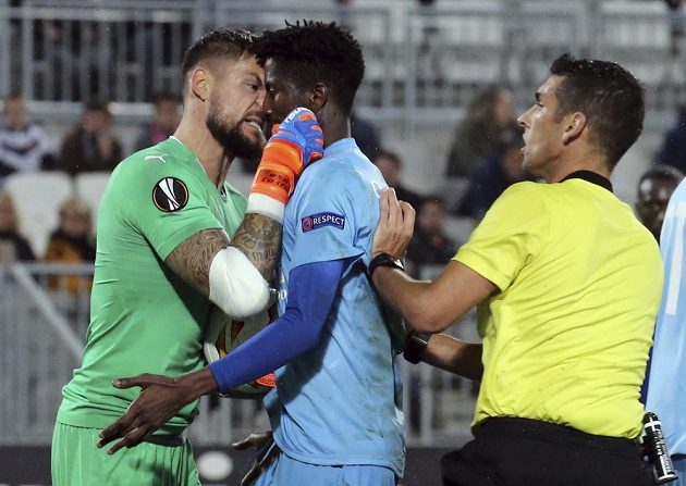 Gólman fotbalistů Bordeaux Benoit Costil si vyříkává jednu z ostřejších situací v utkání Evropské ligy se slávistou Peterem Olayinkou.