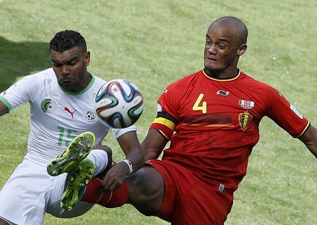 Belgický kapitán Vincent Kompany (vpravo) brání útočníka Alžírska Arbího Hilála Súdáního.