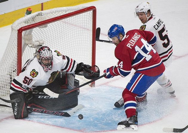 Brankář Chicaga Blackhawks Corey Crawford zlikvidoval střelecký pokus útočníka Montrealu Tomáše Plekance, kterého se snaží atakovat další hráč Blackhawks Brian Campbell.
