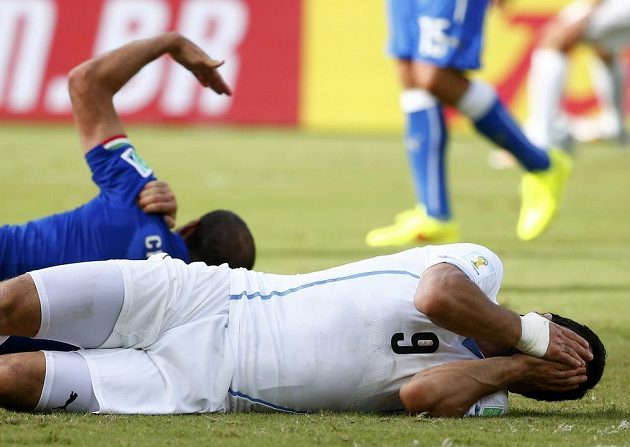 Italský obránce Giorgio Chiellini si drží rameno, uruguayský snajpr Luis Suárez (vpředu) zase obličej. Bude za kousnutí soupeře potrestán?