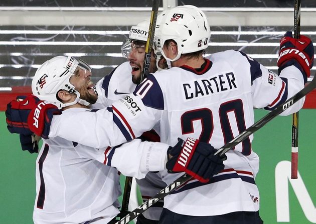 Američan Nate Thompson (uprostřed) slaví svoji trefu ve čtvrtfinále MS proti Rusku v objetí spoluhráčů Stephena Gionty (vlevo) a Ryana Cartera.