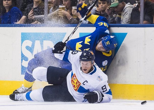 Fin Mikko Koivu (dole) ve tvrdém souboji o kotouč se Švédem Gabrielem Landeskogem.