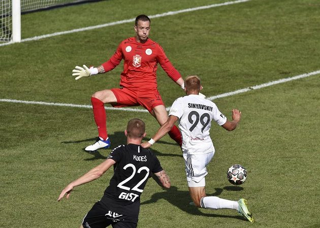 Vlasij Sinjavskij from Karviná overcomes Vilém Fendrich in the goal of Hradec Králové.  Hradec Králové midfielder Petr Kodeš is watching this event.