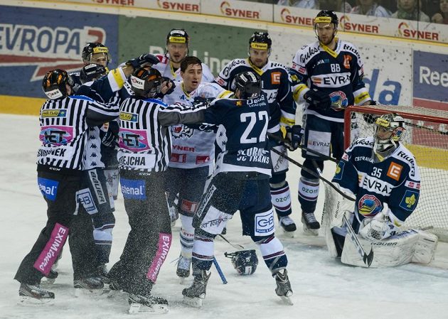 Potyčka před brankářem Vítkovic Filipem Šindelářem. Liberecký Jaroslav Vlach (bez přilby) a Karol Sloboda z Vítkovic (č. 22).