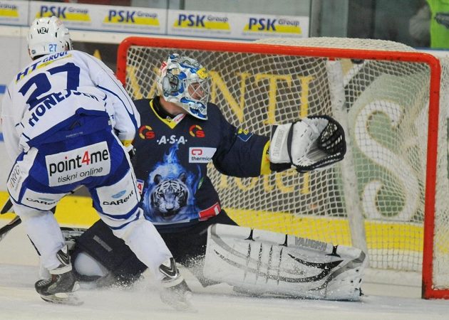 Brněnský útočník Antonín Honejsek střílí gól libereckému brankáři Jánu Lašákovi v utkání 40. kola Tipsport extraligy.