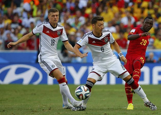 Ghaňan Asamoah (vpravo) bojuje o míč s Němci Mesutem Özilem (uprostřed) a Tonim Kroosem.
