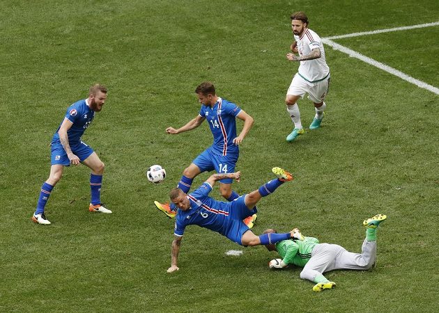 Maďarský brankář Gábor Király (v zeleném dresu) chyboval, neudržel centr a po následném závaru byl nařízen pokutový kop pro Islanďany. Přes gólmana padá Ragnar Sigurdsson (6).